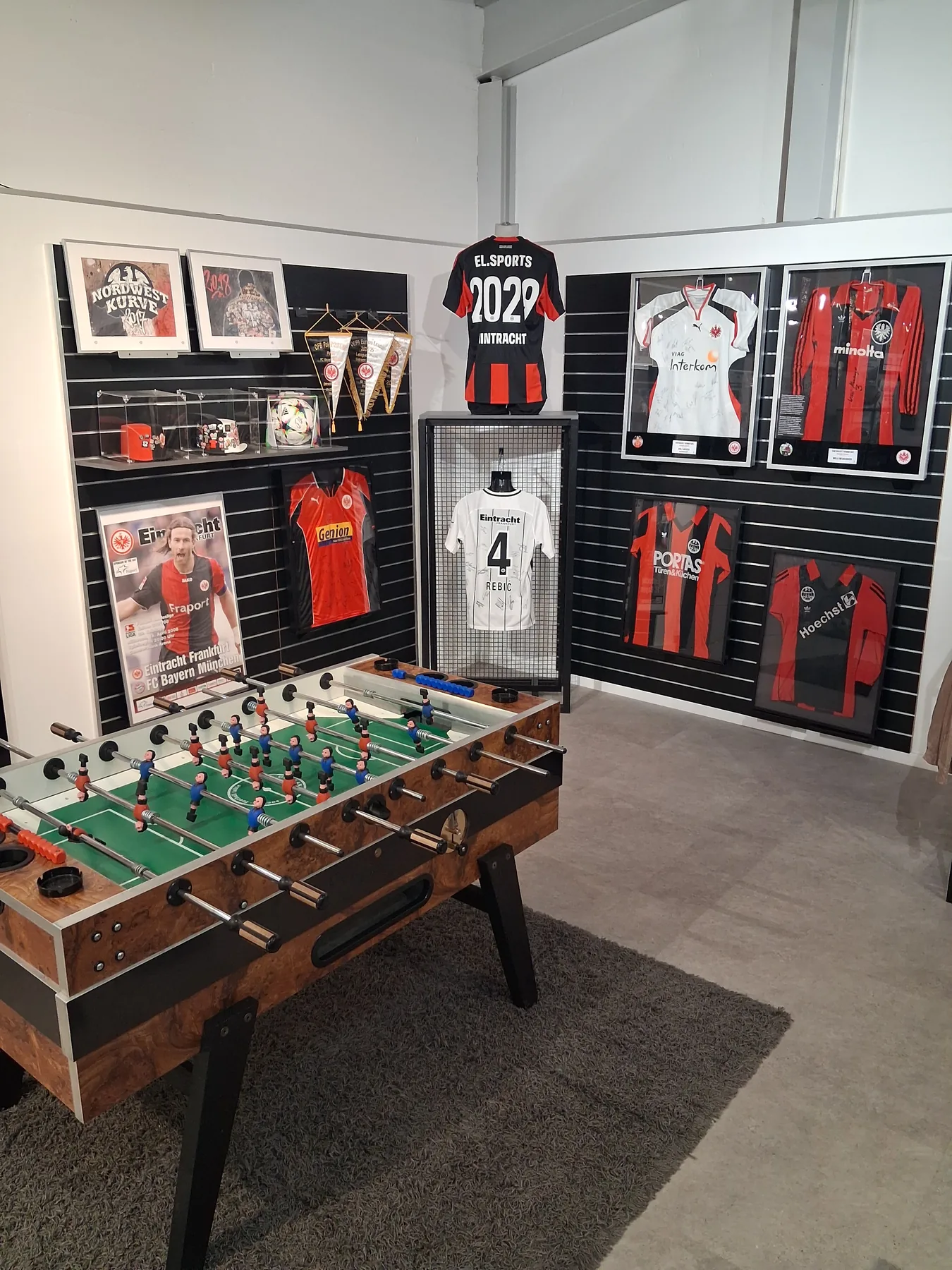 Eintracht Frankfurt Fanartikel an der Wand neben einem Kickertisch